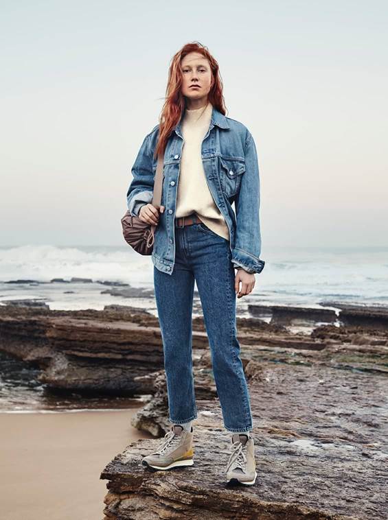 Woman standing on rock in jeans